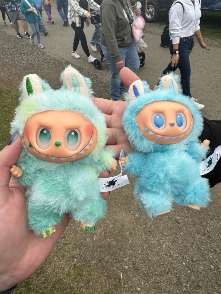 two labubus. one is green, the other is blue.