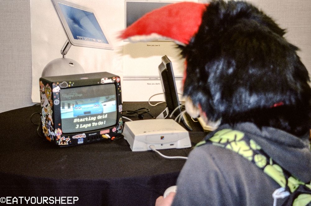 Meros, the rabbit, is playing on an Apple Pippin. You can now see the CRT that he is playing on, as well as some 2000s-era Apple posters in the background.