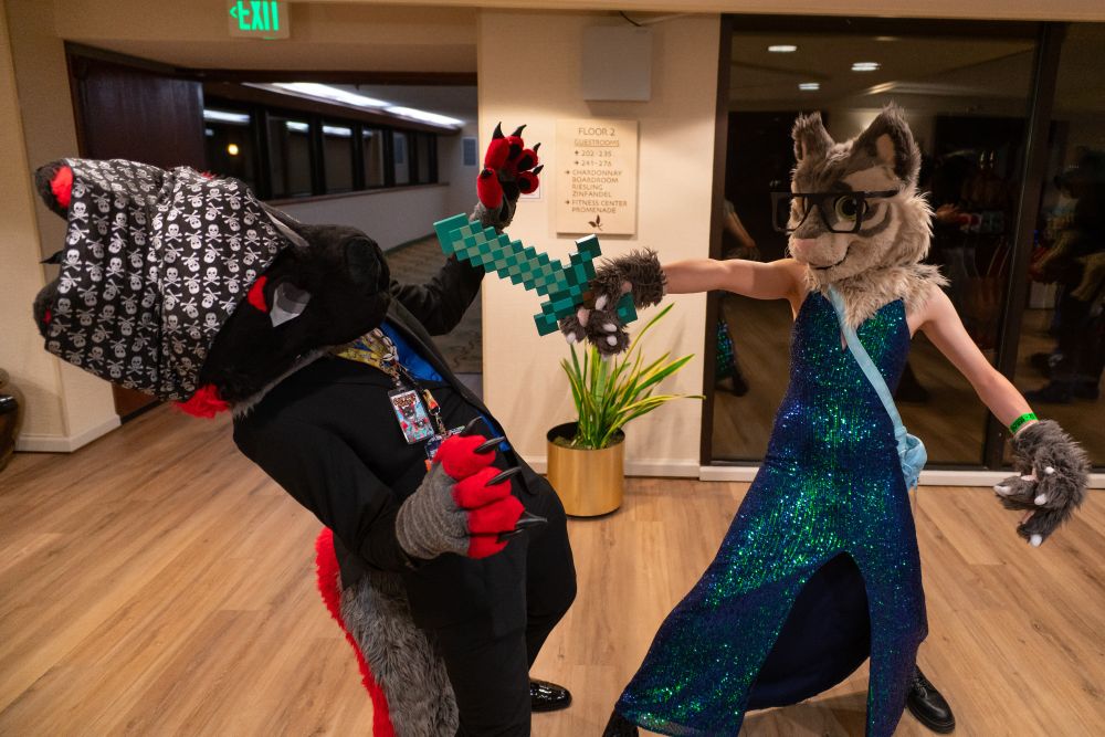 Mílur—in a pirate outfit—avoiding a sword blow from Andrew—who is in a dress, holding a Minecraft sword.