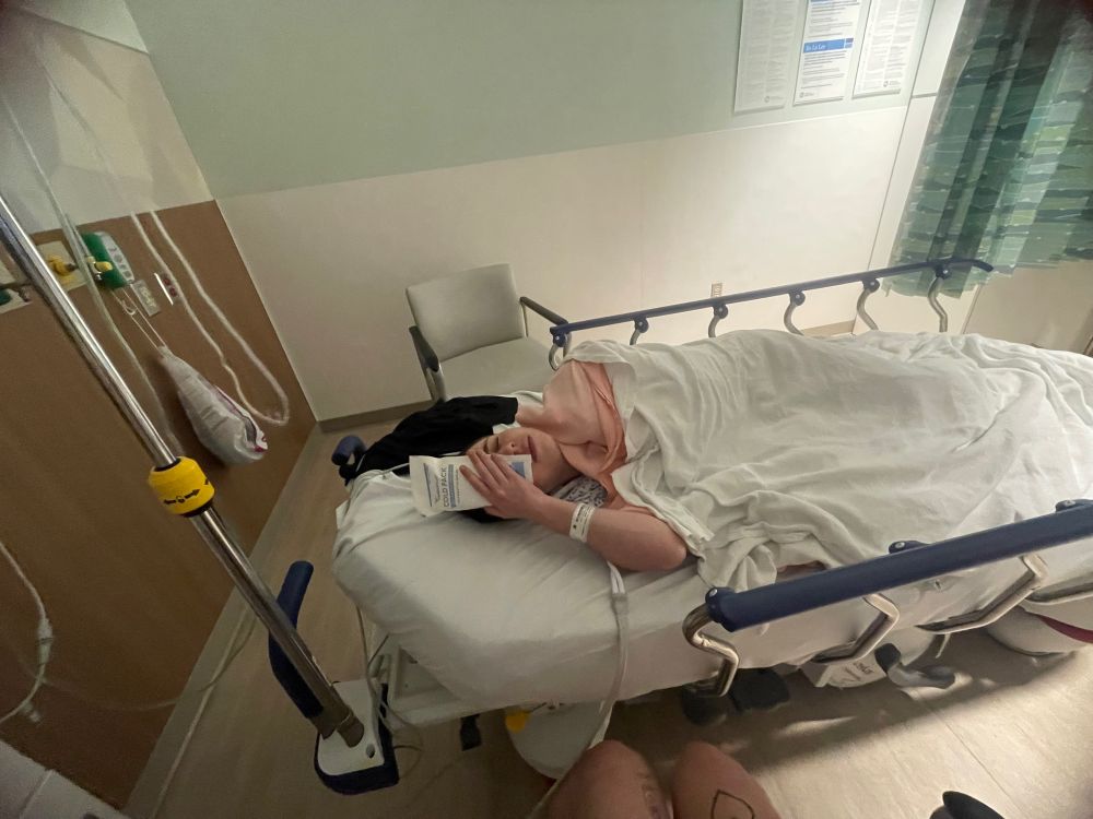 Judah in a hospital bed with an icepack to his eye 