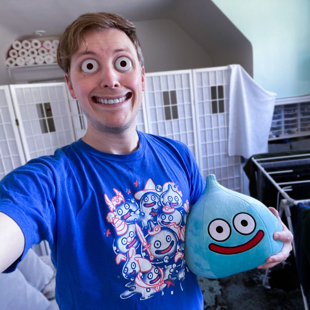It's me, but my face has melted and morphed and distorted to imitate a Dragon Quest slime. I'm also holding a plush slime and wearing a t-shirt with a bunch of slimes on it. It's slimes all the way down!