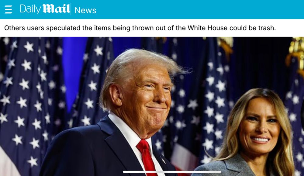 Donald and Melanie Trump stand in front of American flags.