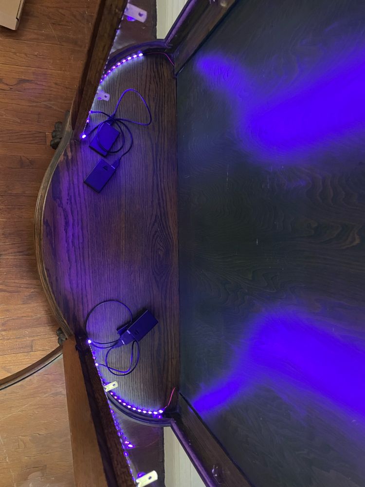 Strips of black light LEDs inside a China cabinet.