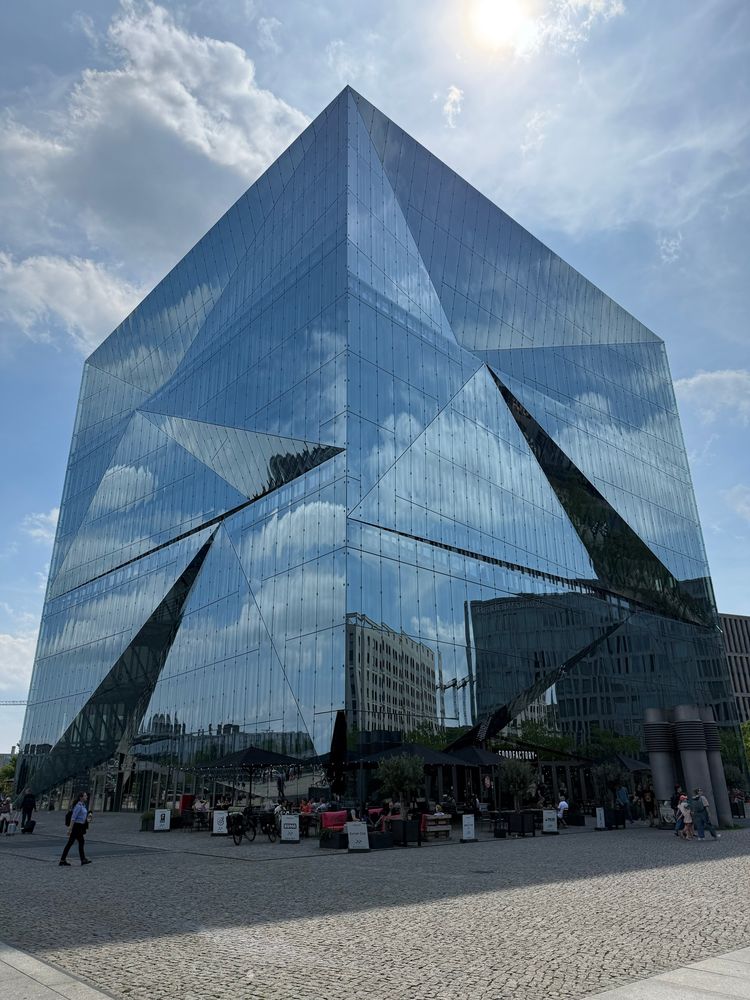 Cubic kind of building with a mirror facade. The facade is a juxtaposition of triangles which allows for fun mirror twists.