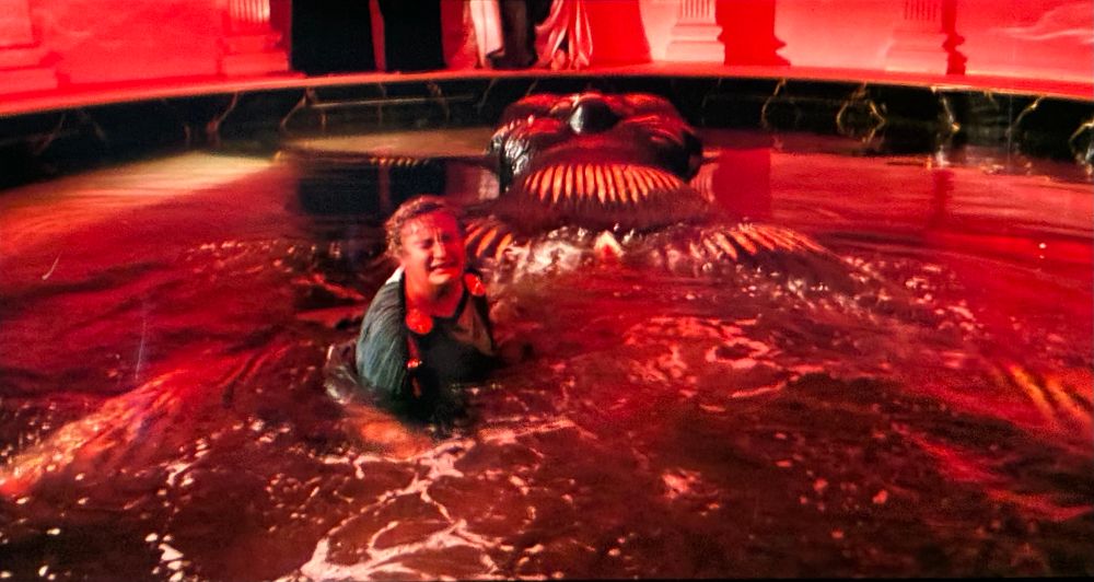 A colossal statue of a hawk-headed Egyptian deity in a temple pool, in which a very unhappy Claudius (Giancarlo Badessi) splashes disconsolately. 