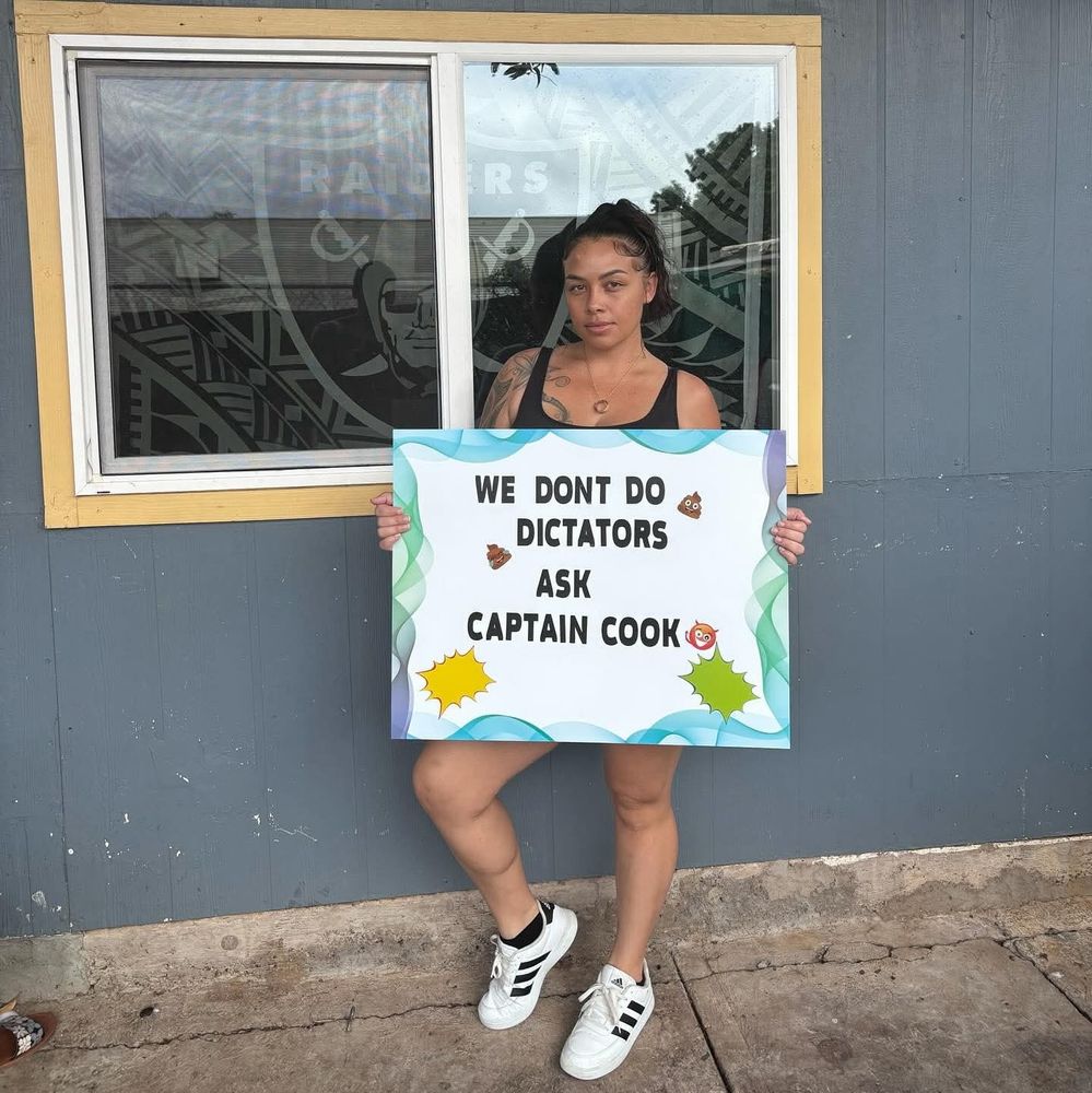 Local Maui girl holding sign saying " We dont do dictators. Ask Captain Cook."