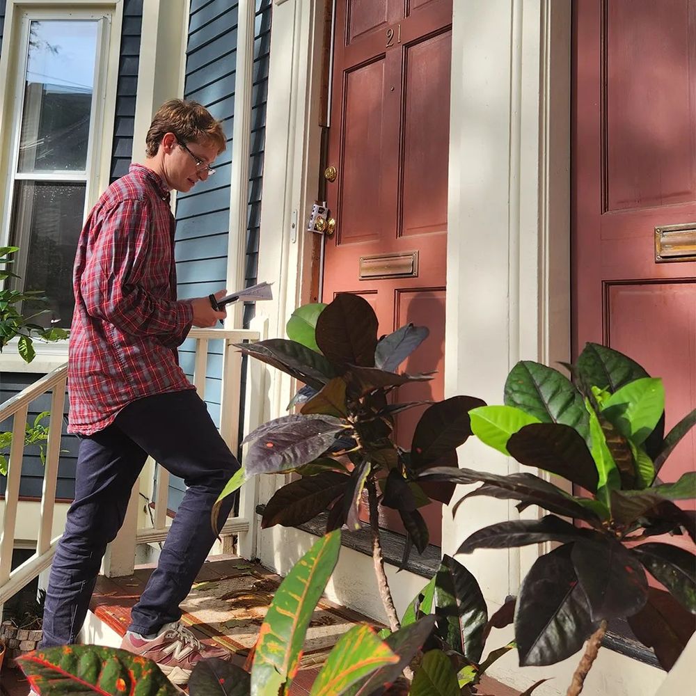 Me (wearing red plaid shirt) leaving a flyer at a door