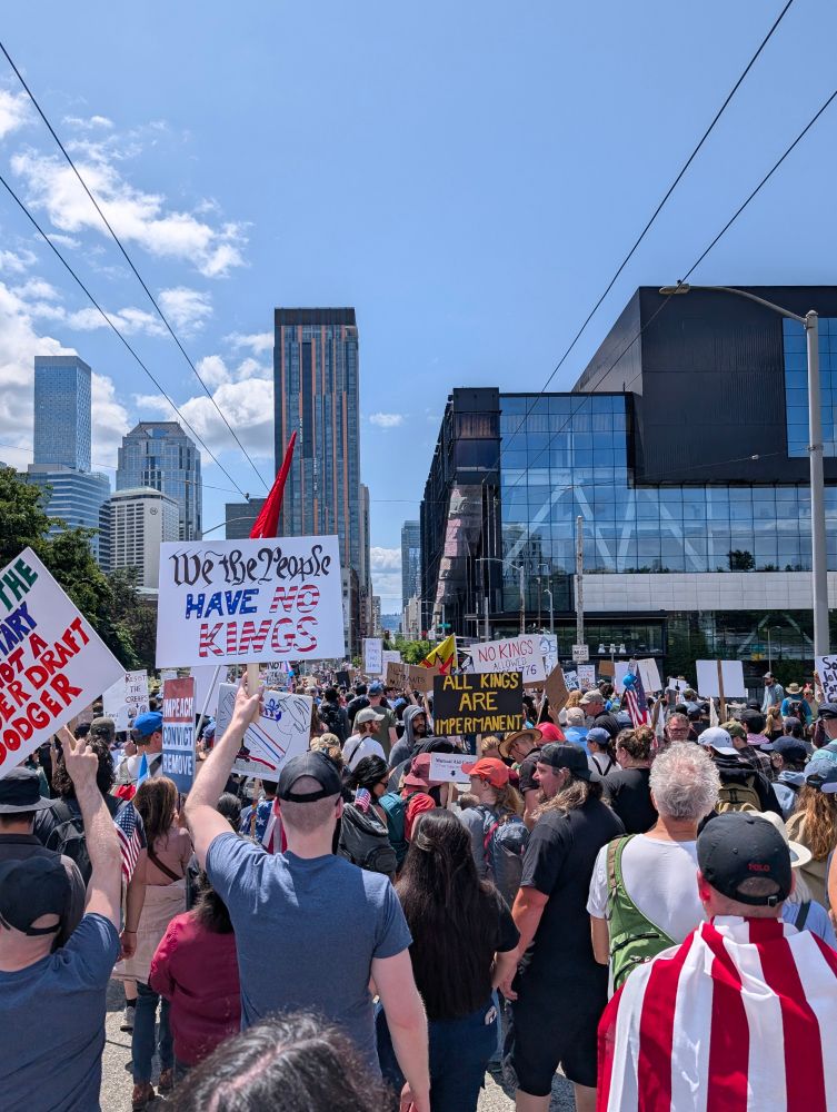 A protest march with sky scrapers and a convention center in the background