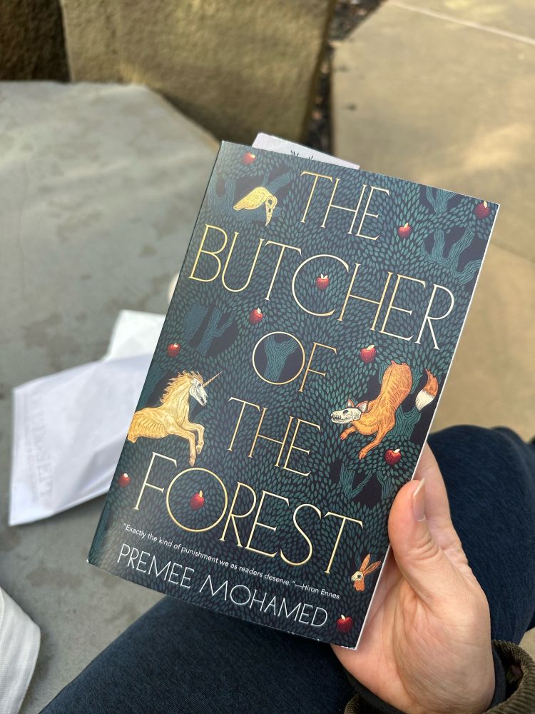 Premee Mohamed’s Butcher of the Forest. The cover is a tapestry like illustration with woodland animals who have skulls for heads and tiny red fruit. The title is rendered in a thin semi serif. 
