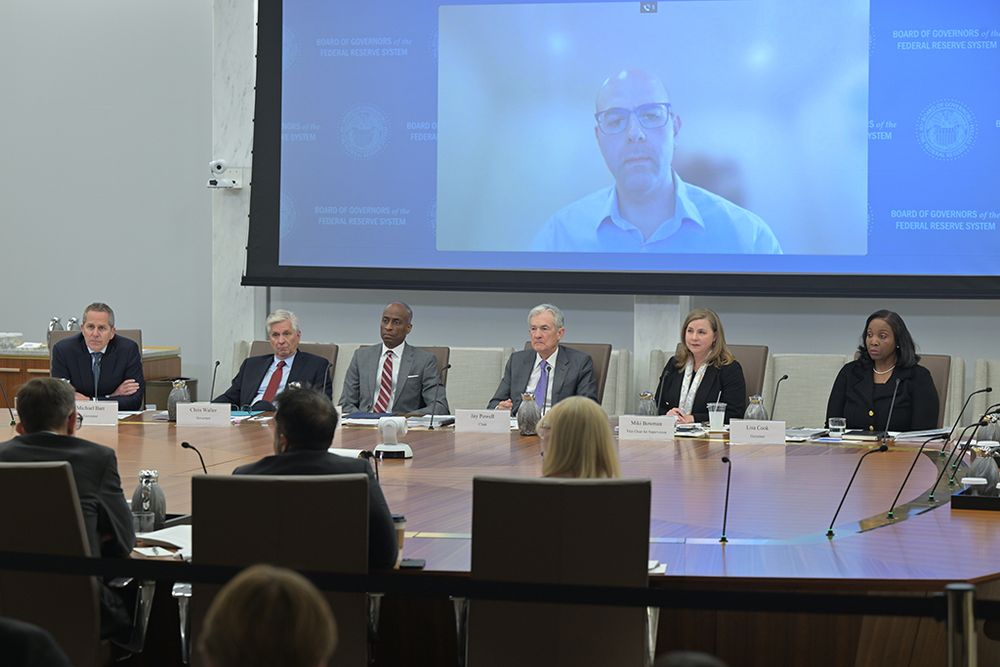 Board members listen to staff present at an open meeting on stress tests transparency