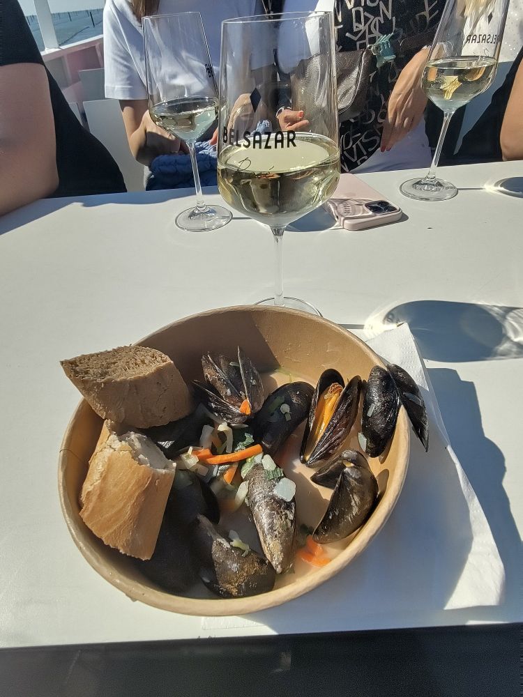 Schüssel voll Miesmuscheln und Glas Weißwein