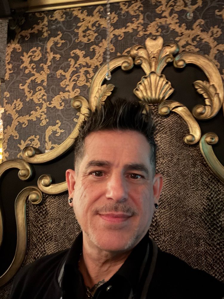 Portrait of myself in front of a golden and black baroque backdrop. 