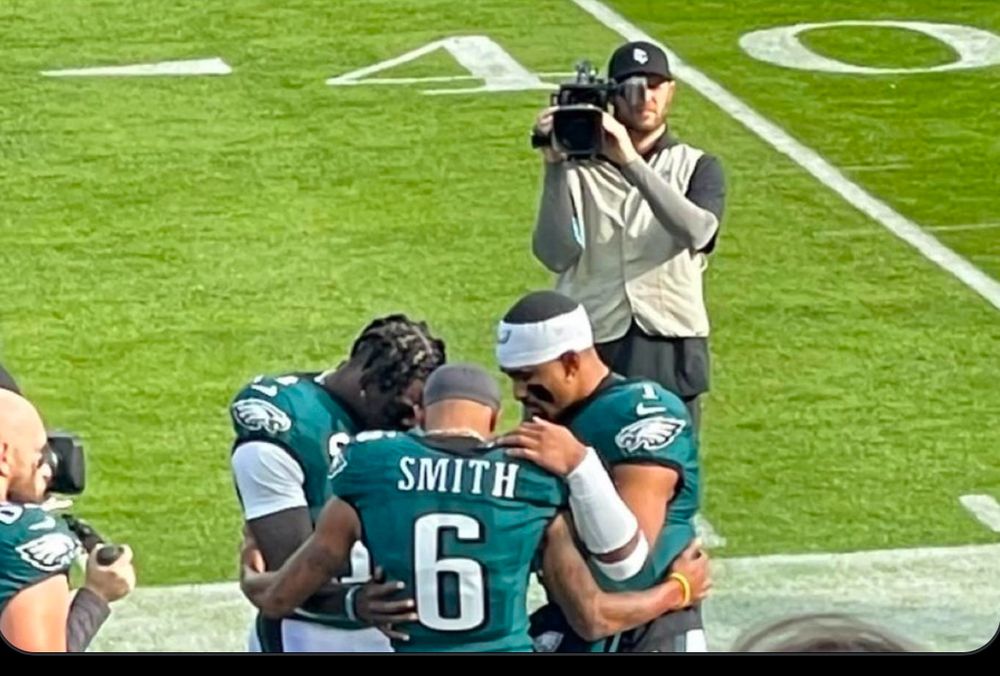 Jalen Hurts praying with his wide receivers, Devontae Smith and AJ Brown, before the Eagles vs Panthers game. 