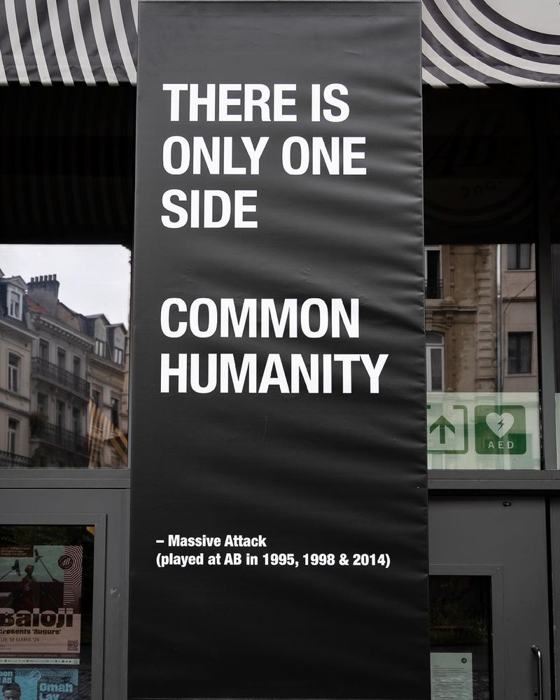 Black banner with the words "There is only one side, common humanity" written on it. It hangs at the front of AB concert Hall in Brussels.