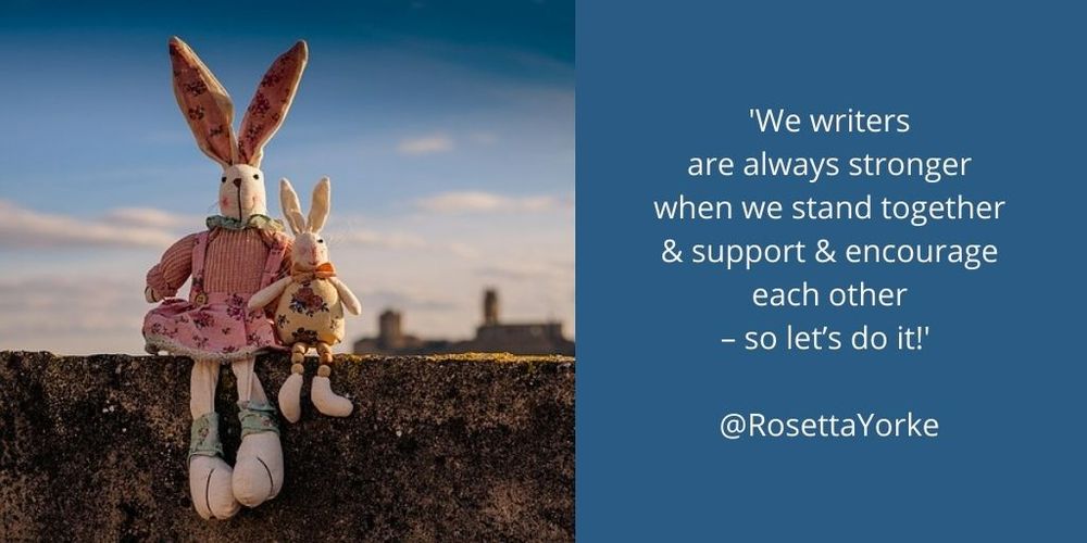 Two cute toy rabbits, one tall & one small, sitting on a moss-covered stone wall, with hazy buildings in the distance.