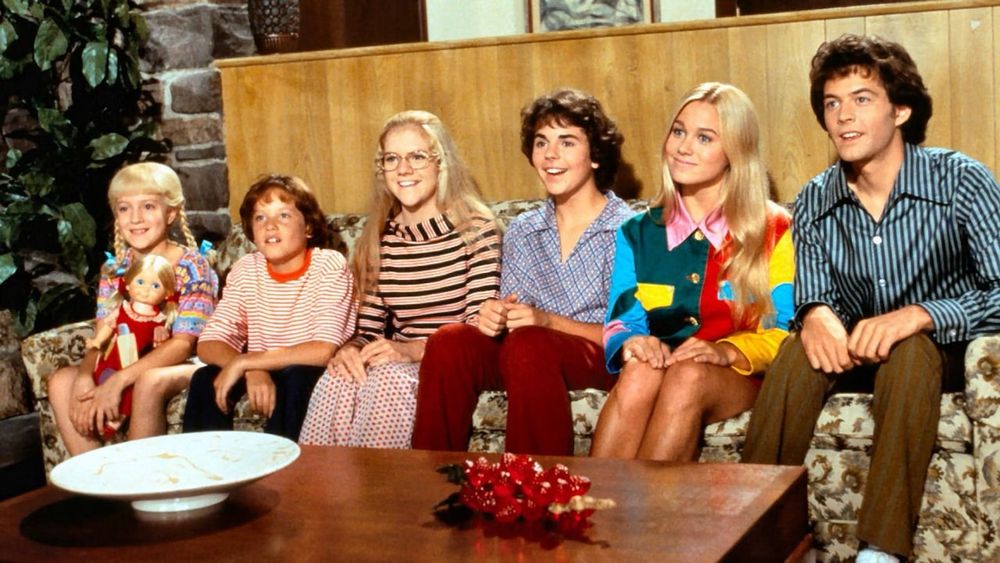 The Brady kids sitting on the couch in the Brady Bunch movie.