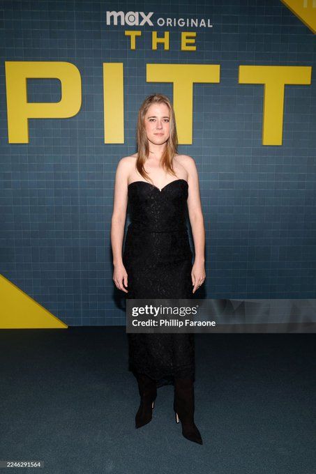 Taylor Dearden at the FYC SAG event for Season 2 on the red carpet. She wears a black short dress with a sweetheart neckline and bare shoulders. Her long blond hair falls open around her shoulders and she rocks black high heel boots.