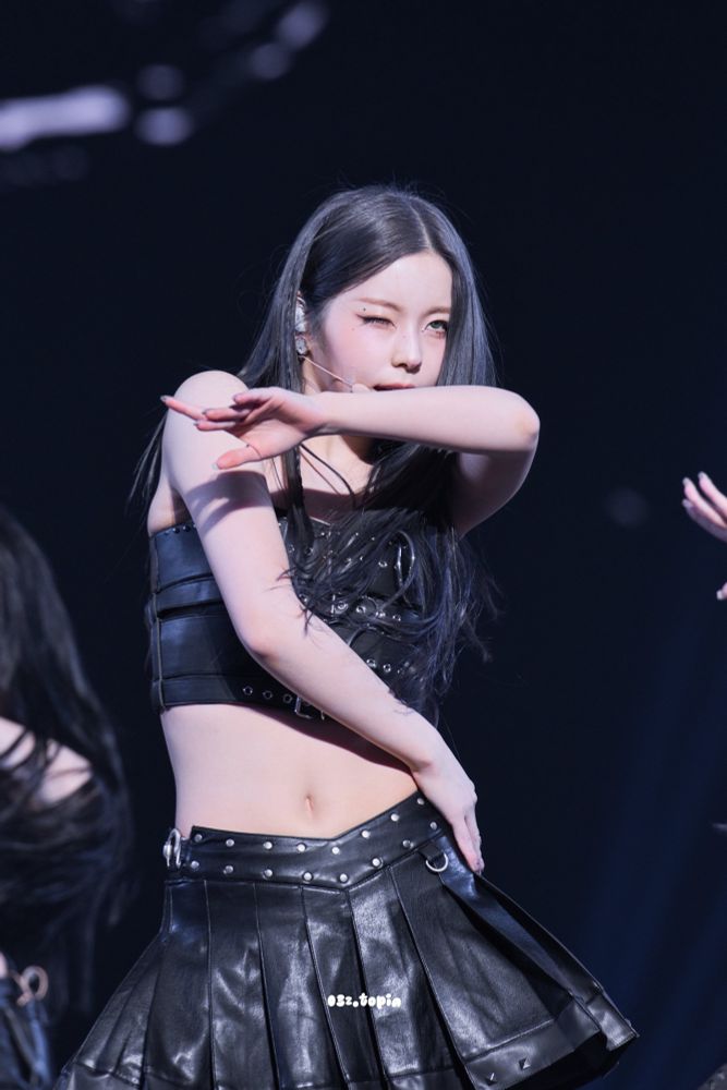 Kyujin in a black crop top and black skirt 