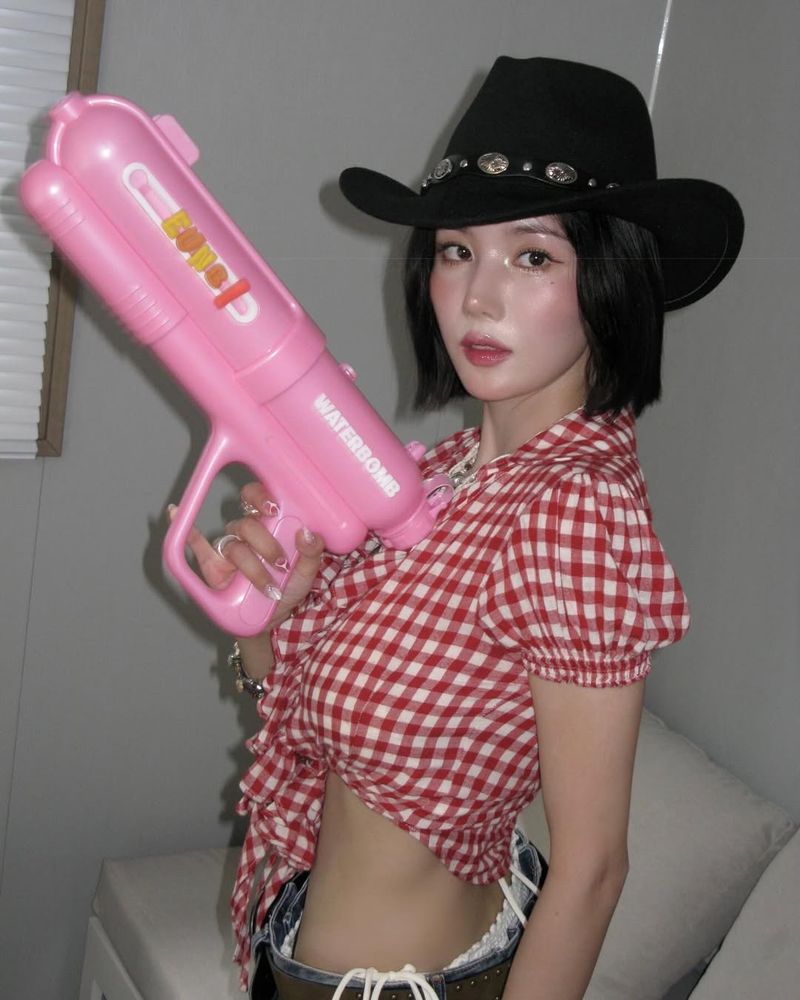 Eunbi with a water gun and cowgirl hat