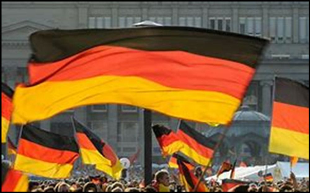 Über den Köpfen von Menschen werden zahlreiche Deutschlandfahnen sprich Schlandlappen gehalten.