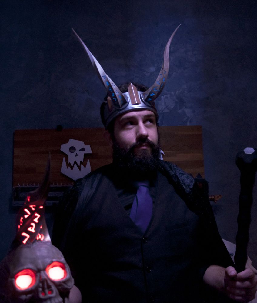 Jon, vêtu de la même façon, porte toujours la couronne sur la tête, mais cette fois il tiens dans la main droite un crane démoniaque illuminé de rouge, dans la main gauche une canne noire.