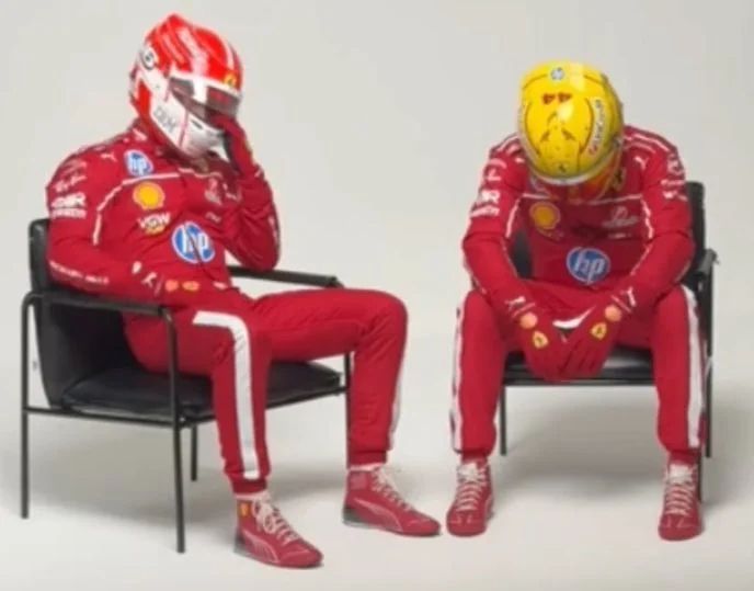 Lewis Hamilton & Charles Leclarc, still in their racing uniforms and helmets sitting down on chairs and looking sorry for themselves. i.e. Standard Ferrari.