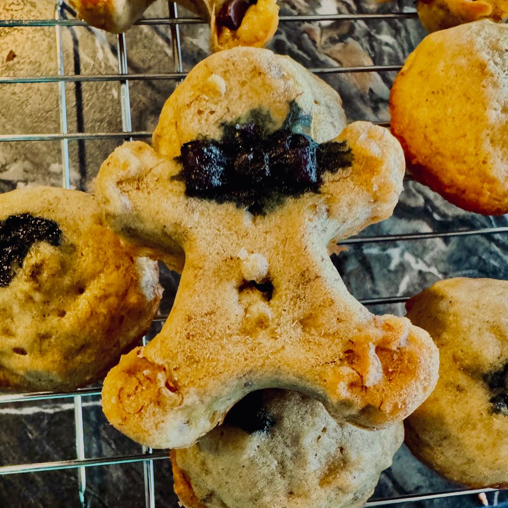 Banana bread muffins, some in the shape of gingerbread men - blueberry exploded behind one of their bow ties. 
