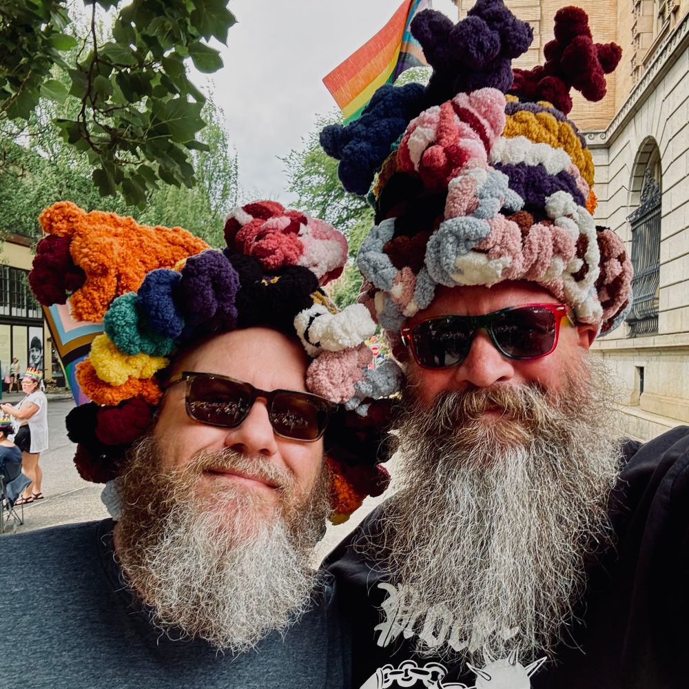 Bearish, bearded men in pride-colored yarn hats and sunglasses. 