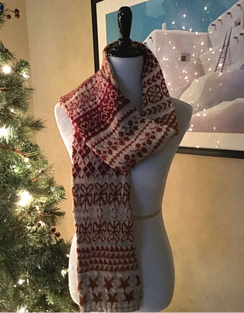 Colorwork tube scarf on a dressmaker form beside a lit Christmas tree