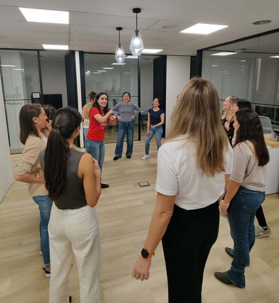 Foto de las participantes durante una de las dinámicas, de pie y formando un círculo.