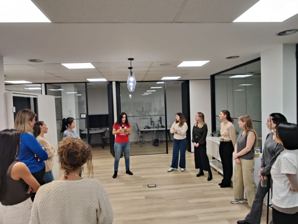 Foto de las participantes durante una de las dinámicas, de pie y escuchando a María que explica el ejercicio. 