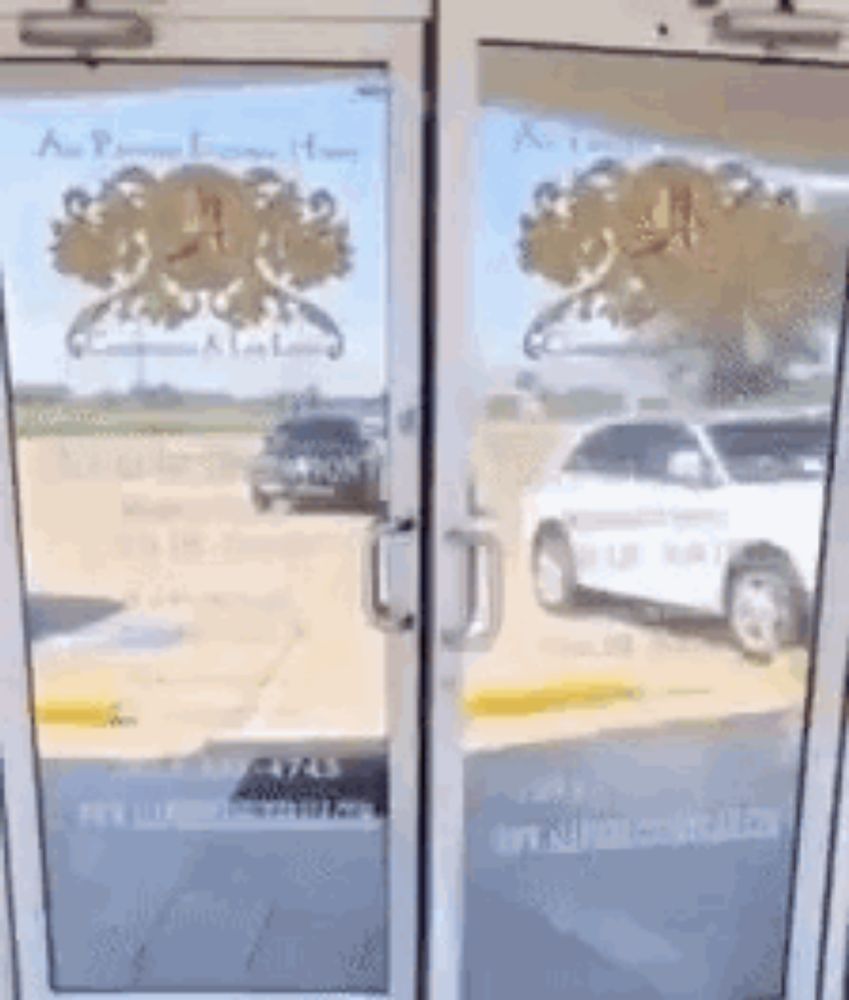 a car is parked in a parking lot in front of a glass door .