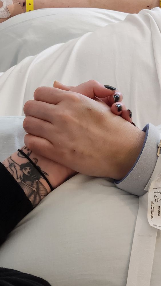 My niece holding her mom's hand in the hospital. 