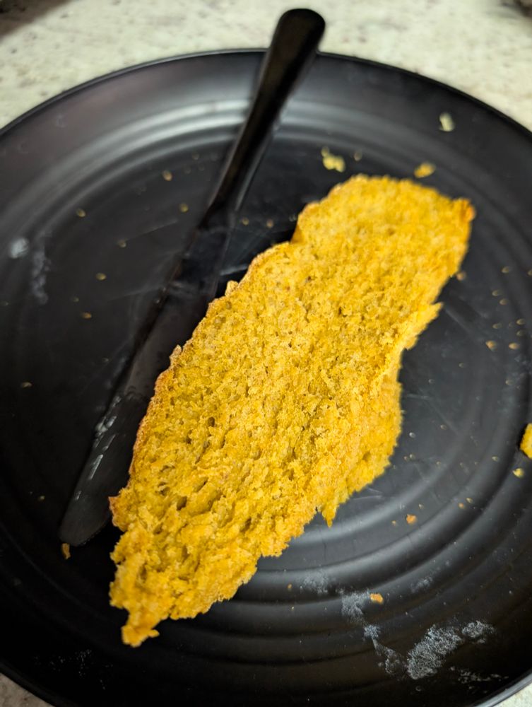 Cut piece of bread on a black plate