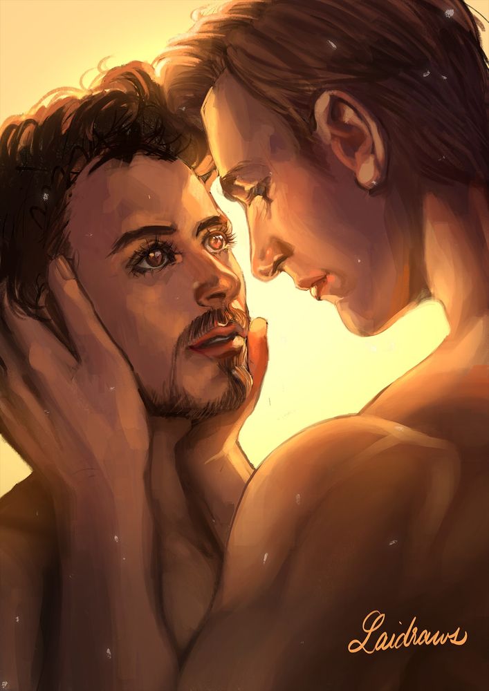 Steve Rogers holding Tony Stark's face, both bathed in a warm glowing light.
