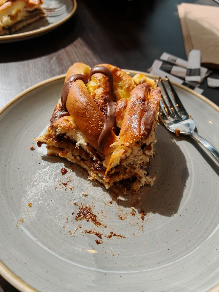 Vegan cinnamon bun style cake on a pair, partially eaten. 