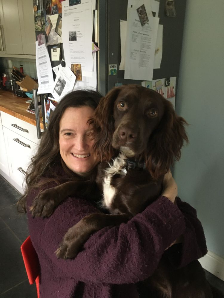 Woman with brown spaniel on her lap.