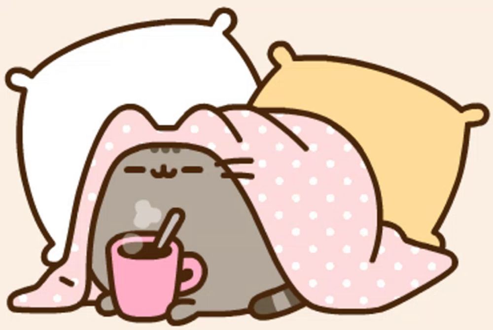 a cat is laying under a blanket holding a cup of hot chocolate