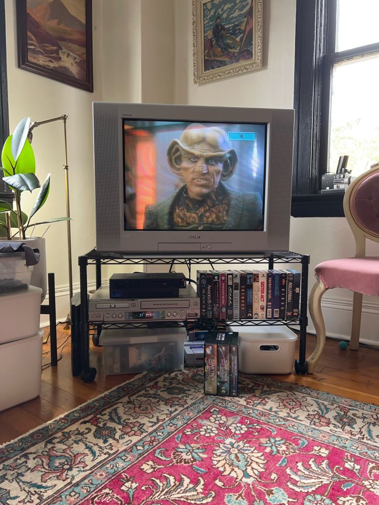 A living room media center with an episode of Deep Space Nine on the TV. 