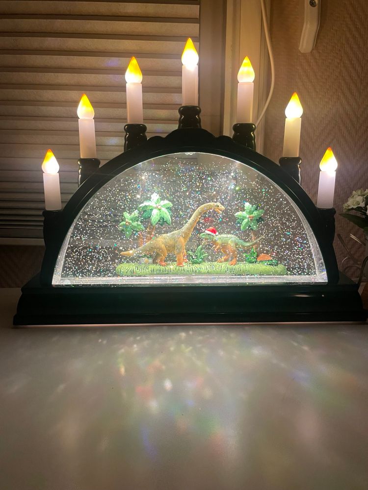 Syvarmet lysestake med dinosaurer, den ene med nisselue, inni.