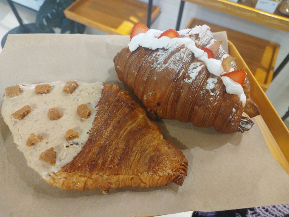 a flattened biscoff croissant and a strawberry croissant