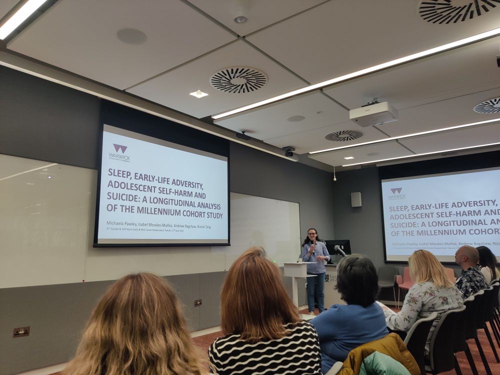 Michaela speaking in front of a group of self-harm and suicide researchers