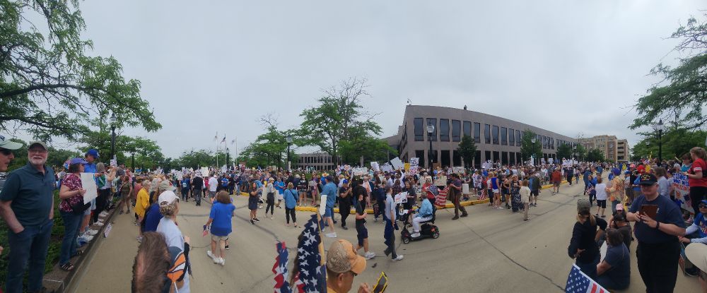 A bunch of people standing around in protest of President Trump's abuse of his position.
