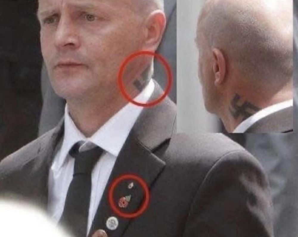 Man with a swastika tattoo wearing a red poppy.