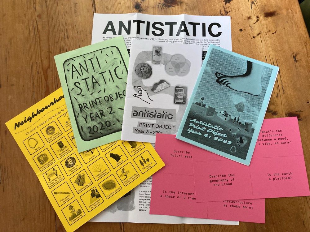 A series of zines in bright colours laid out on a wooden table