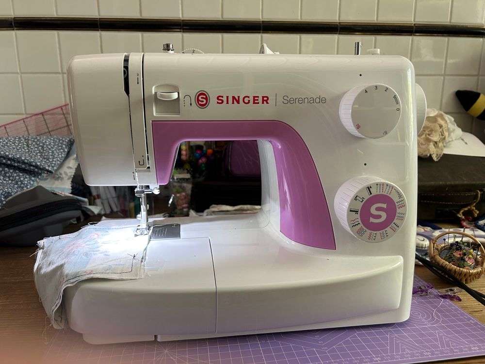 a white-and-pink devil‘s contraption (aka Singer Serenade) that takes perfectly good thread and utterly fails to use it to attach two pieces of fabric to each other.