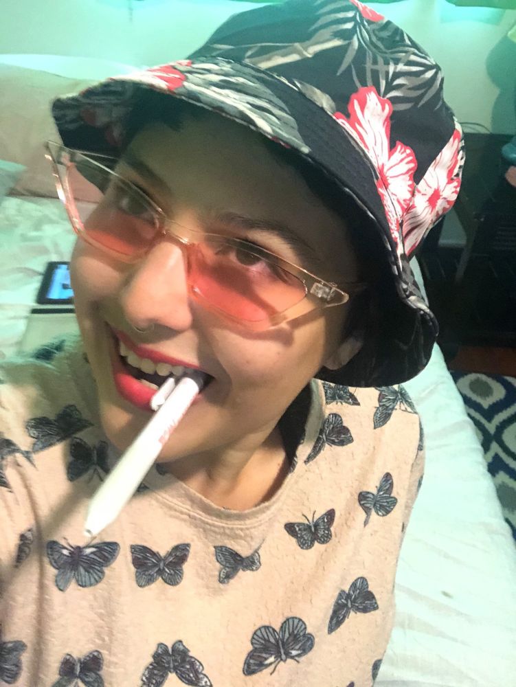 Me wearing a bucket with pink glasses and holding on a pen like it I am Hunter s Thompson holding a cigarette 