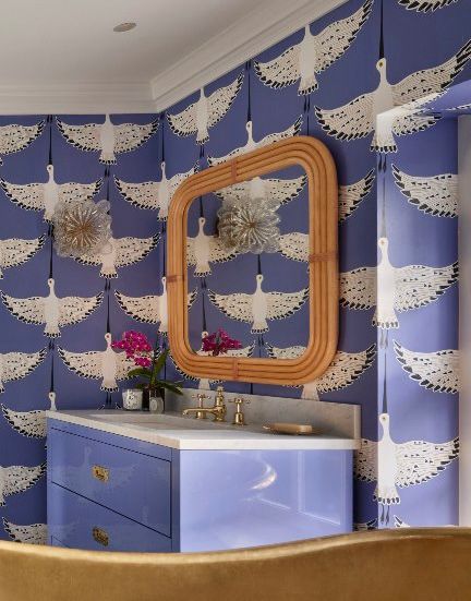 a periwinkle bathroom with a warm honey toned wooden mirror