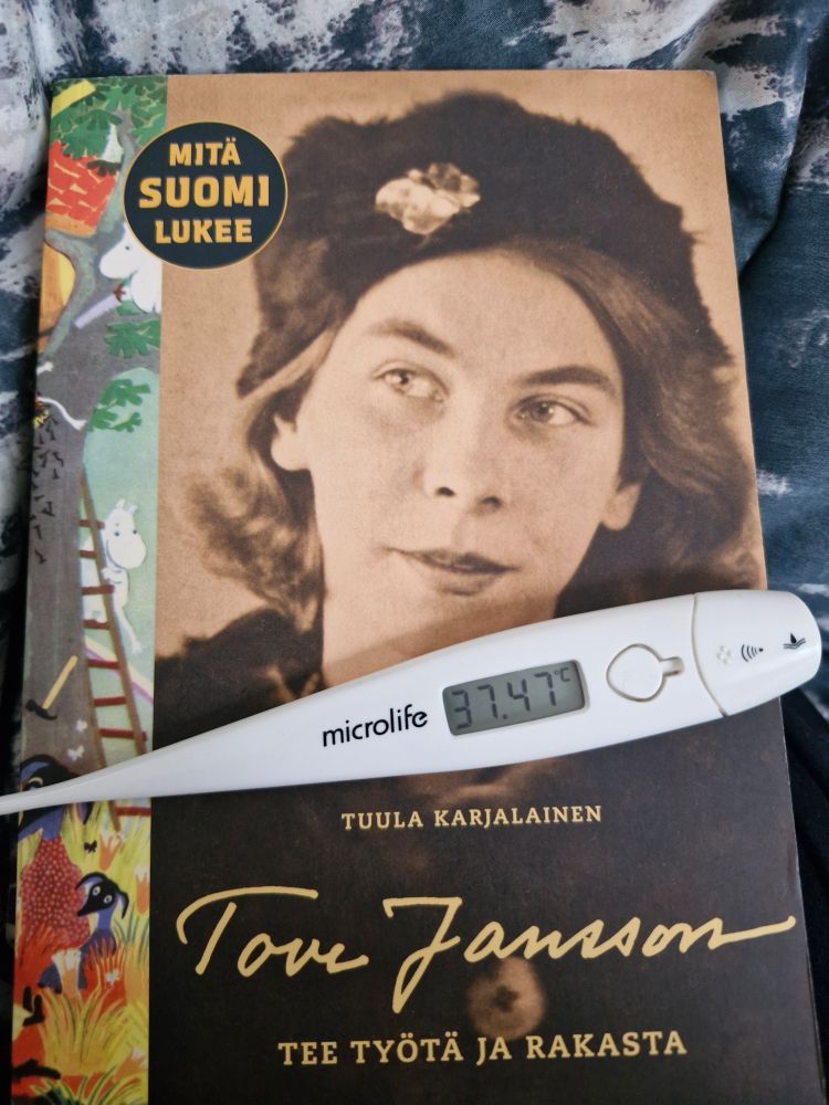 Tuula Karjalaisen kirja Tove Janssonista. Kirjan päällä kuumemittari, jossa lukema 37,47 celsius astetta.