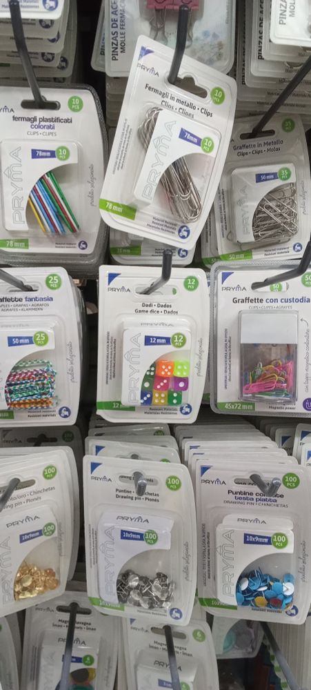 Entre blisters de clips y chinchetas, un blíster de dados de seis de distintos colores